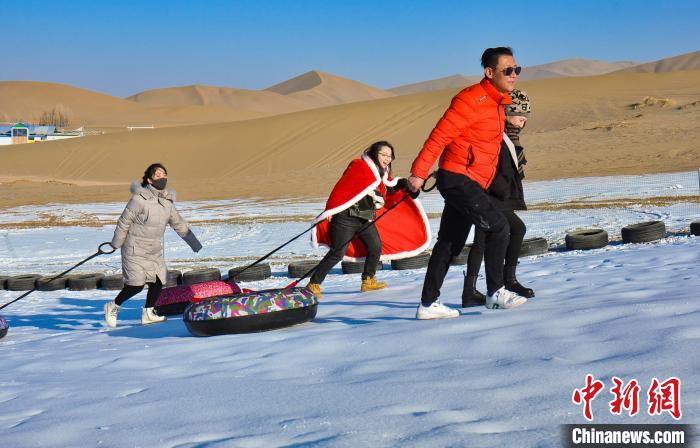 圖為游客和市民在鳴沙山下享受大漠冰雪帶來的歡樂?!⊥醣筱y 攝 圖為游客和市民在鳴沙山下享受大漠冰雪帶來的歡樂?!⊥醣筱y 攝