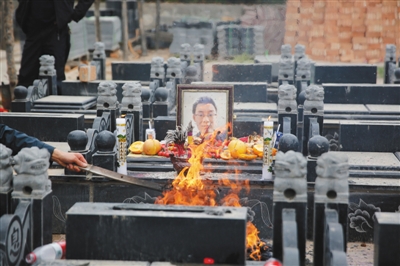 2016年4月13日，陜西咸陽(yáng)，魏則西的墓上擺滿了他生前愛(ài)吃的水果、餅干、巧克力。本版圖片/CFP