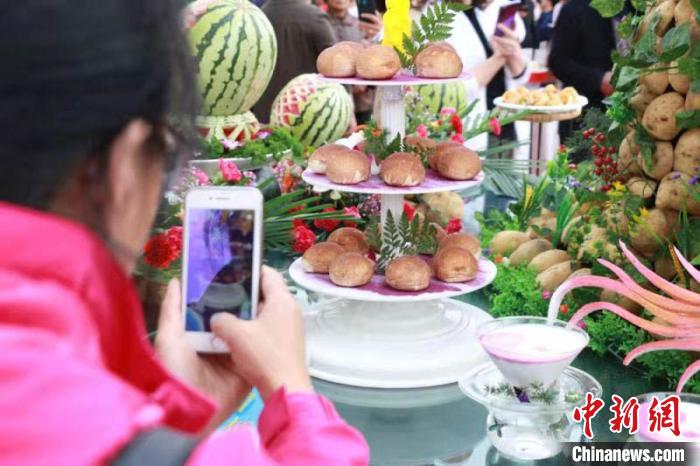 民眾利用手機(jī)給展示臺上優(yōu)質(zhì)馬鈴薯拍照。(資料圖) 張婧 攝
